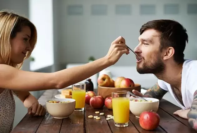 une femme nourrit un homme avec des noix pour augmenter sa puissance